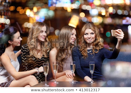 Stock photo: Woman Picturing Friends By Smartphone At Wine Bar