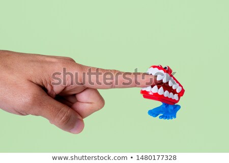 Foto d'archivio: Funny Denture Biting A Finger