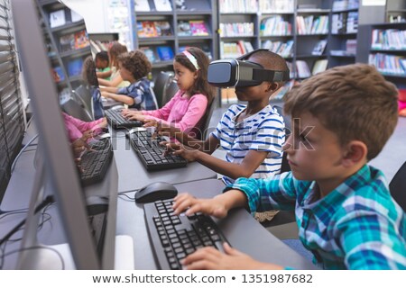 Stockfoto: Side View Of African American Schoolboy Using Virtual Reality Headset While His Schoolmates Working