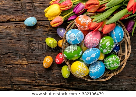 Foto stock: Painted Easter Eggs In Basket And Spring Flowers