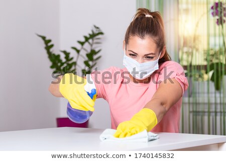 ストックフォト: Beautiful Young Maid Using Duster And Disinfectant Spray