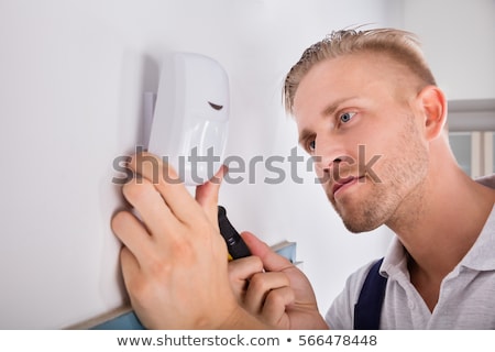 Stok fotoğraf: Electrician Installing Security System Door Sensor On Wall