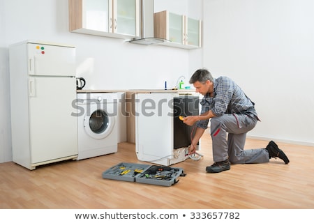 Foto d'archivio: Technician Checking Dishwasher With Digital Multimeter