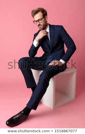 Foto d'archivio: Seated Casual Man Holding Sunglasses And Looking Down To Side