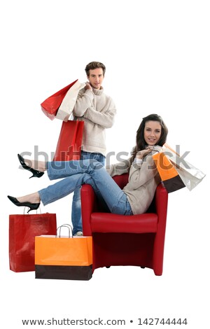 Foto stock: Woman Sitting In A Chair And Surrounded By Shopping Bags