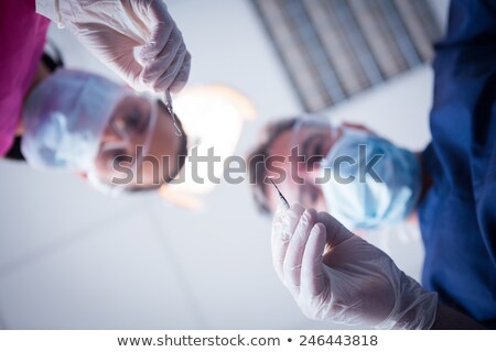 Zdjęcia stock: Dentist In Surgical Mask Holding Tools Over Patient