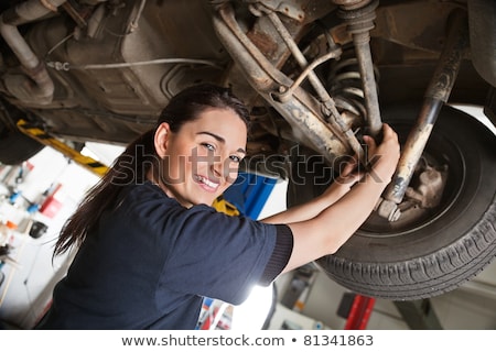 Stockfoto: Smiling Female Mechanic Holding Car Tire