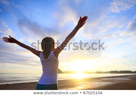 Stock fotó: Woman With Arms Raised Standing On Sand