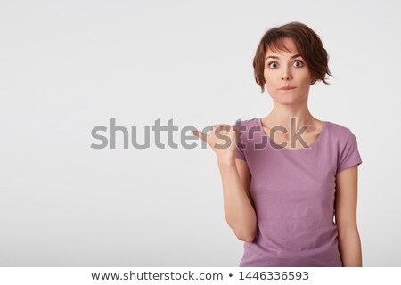 Foto stock: Young Confused Lady Pointing