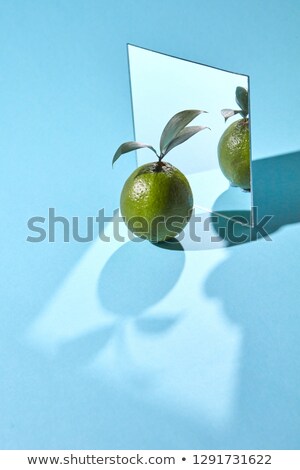 The Composition Of The Leaves And Lime With The Reflection Of The Shadows On A Blue Background With Сток-фото © artjazz