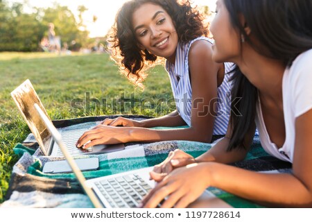 [[stock_photo]]: Close Up Of Two Lovely Young Girls Students Laying On A Grass