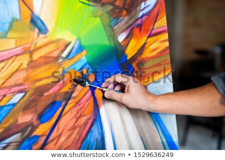 Foto d'archivio: Hand Of Contemporary Painter With Special Instrument Mixing Colors On Paper