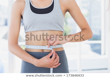 Stok fotoğraf: Woman Measures Body In Room