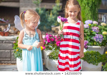 Сток-фото: Sweet Little Girls In A Country Yard With Flowers In Their Hands