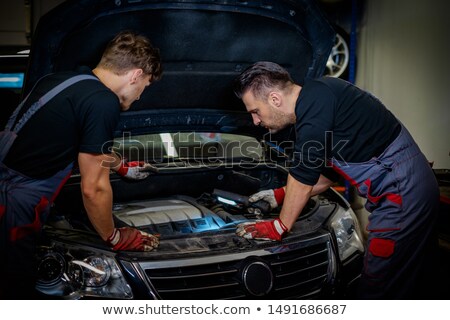Foto stock: Mechanic Examining Under The Car At Garage