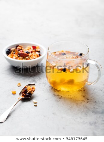 Foto d'archivio: Fruit Tea Dried Fruits And Spices In Transparent Cup On A Grey Stone Background