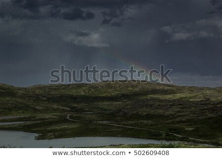 Stockfoto: Beautiful Gloomy Dark Stormy Sky And Rainbow Over A Green Valley