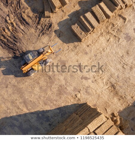 Foto stock: Green Field With Large Haystacks And Tractor On A Sunny Day Aerial View From The Drone