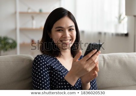 Zdjęcia stock: Portrait Of Pleasant Looking Relaxed Woman Holds Modern Cell Phone Types Text Message On Cell Phone