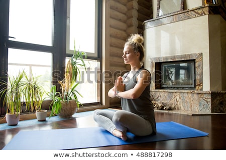 Foto stock: Portrait Of Young Woman With Crossed Legs In Praying Position