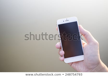 Stockfoto: Spring Flowers Girl Is Holding Smartphone In Hands