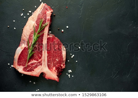 Foto d'archivio: Raw T Bone Steak On Slate Board