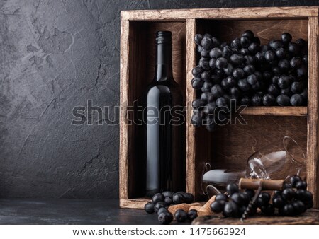 [[stock_photo]]: Bottle Of Red Wine And Empty Glasses With Dark Grapes With Corks And Corkscrew Inside Vintage Wooden