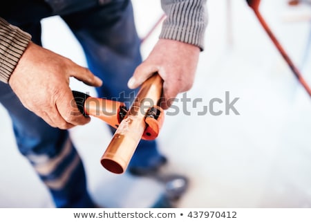 Stock fotó: Plumber Cutting A Copper Pipe With A Pipe Cutter