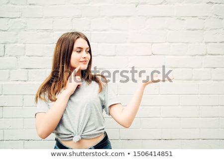 Zdjęcia stock: Woman Looking Her Hand Presenting Something Against White Background