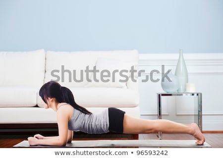 Zdjęcia stock: Side View Of Young Woman In Yoga Pose On Hardwood Floor