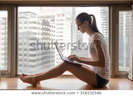 Stockfoto: Young Smiling Woman Sitting Next To Laptop