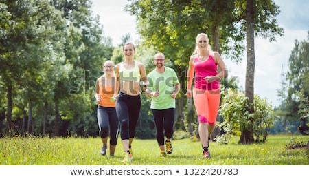 Family With Personal Fitness Trainer Jogging Foto d'archivio © Kzenon