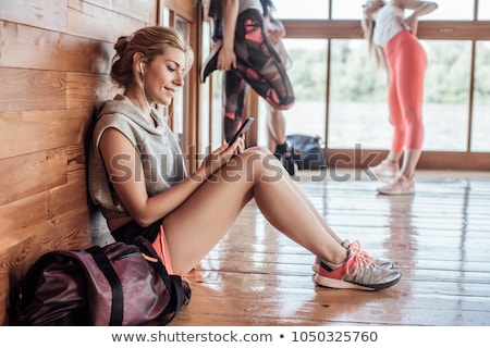 Stock fotó: Sporty Woman With Smartphone Sitting Indoors