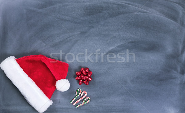 Erased black chalkboard with Santa cap and candy canes plus gift Stock photo © tab62