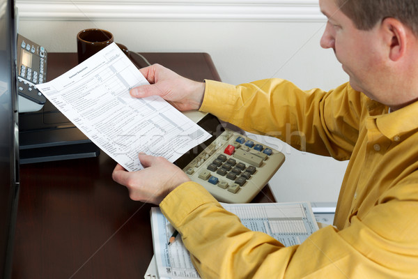 Mature Man looking at Tax Form Print Out  Stock photo © tab62