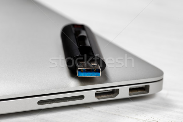 Stock photo: Thumb drive with fast USB speed technologies on top of computer 
