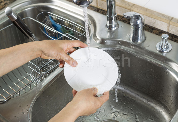 Woman hands washing dinner plate in kitchen sink  Stock photo © tab62