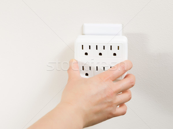 Hand plugging in Multiple Electrical Unit into Wall Outlet  Stock photo © tab62