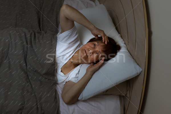 Restless senior woman staring at ceiling during nighttime while  Stock photo © tab62