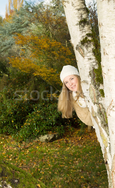 Happy Woman peeks out from behind Tree  Stock photo © tab62