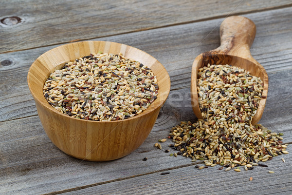 Raw Rice in wooden kitchenware spilling onto rustic wood Stock photo © tab62