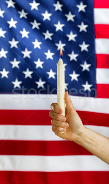 Hand holding lit candle with blurred out USA flag in background  Stock photo © tab62
