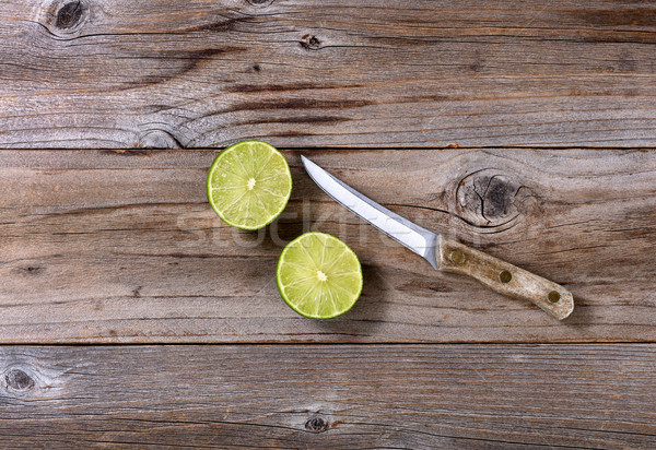 Sliced lime and paring knife on rustic wood in flat lay format Stock photo © tab62