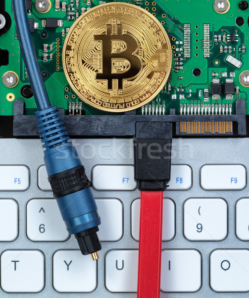 Bitcoin coin on circuit board of computer with fiber optic cable Stock photo © tab62