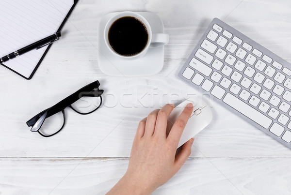 Stock photo: Female hand using computer mouse on organized white desktop 