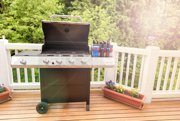 Bright daylight on deck wiht open barbecue cooker and bottled be Stock photo © tab62