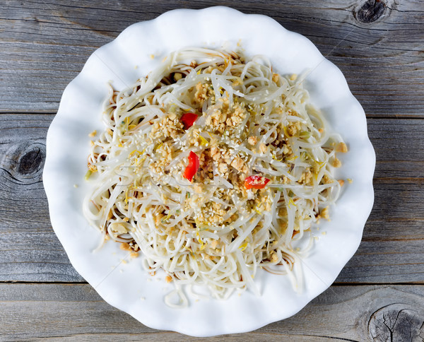 Fresh Asian noodle dish with vegetables on rustic wood backgroun Stock photo © tab62