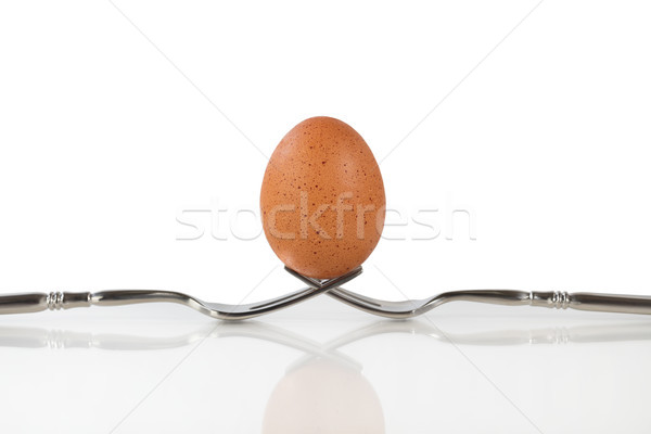 Isolated whole brown egg balanced on two forks Stock photo © tab62