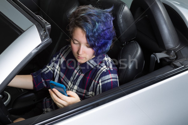 Girl teenager driver concentrating on texting while seated in sp Stock photo © tab62