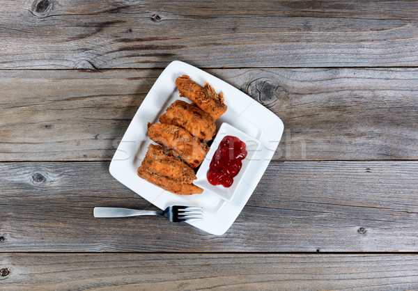 Overhead view of deep fried fish in plate on rustic wooden table Stock photo © tab62